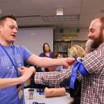 Opstad Elementary Schools principal Ryan Hill and math teacher Ryan Vidos practice using tourniquets as part of the Stop the Bleeds training. Madison Miller/staff photo.