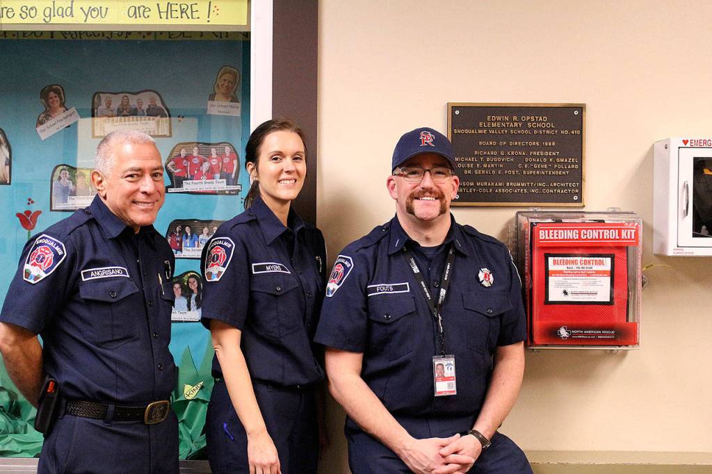 Snoqualmie Fire Department Lts. Robert Angrisano, Kristina Myers and Jake Fouts pose near Opstad Elementarys new Stop the Bleed kit. Madison Miller/staff photo