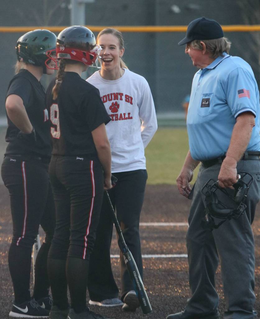 Mount Si head coach Lauren Dumoulin jokes with her players and an umpire. Andy Nystrom / staff photo