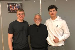 Mount Si lineman Cody Frederick, left, and Mount Si wide receiver Jonny Barrett, right, pose for a photo with Wildcats head coach Charlie Kinnune. Photo courtesy of Charlie Kinnune