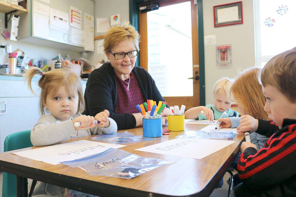 Preschool lead teacher Nikki Slaght helps her toddler class write their names. Stephanie Quiroz/staff photo