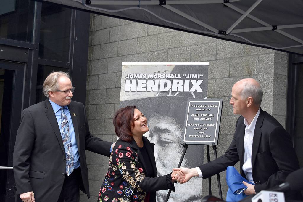 USPS district manager Darrell Stoke, Janie Hendrix and Congressman Adam Smith (D-WA) unveil the plaque honorarily naming the Renton Highlands Post Office as the James Marshall Jimi Hendrix Post Office on Friday, April 19. Photo by Haley Ausbun