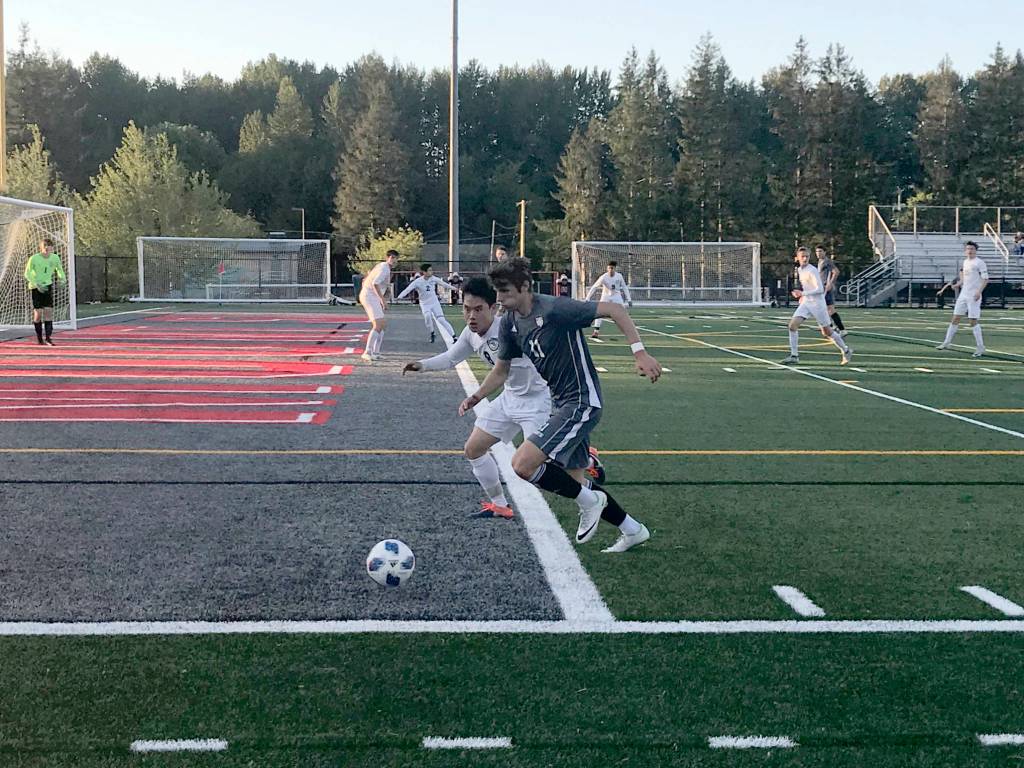 Mount Si Wildcats senior Drew Harris chases the ball while being defended by Jacksons Minhyok Kim in the first half of play. Jackson defeated Mount Si in an overtime penalty kick shootout (6-5) en route to a 3-2 victory in the Wes-King 4A boys district soccer tournament championship game on May 9 at Mount Si High School in Snoqualmie. Shaun Scott/staff photo