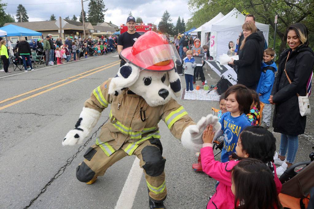 The Fall City Fire Departments mascot high fives a group of kids during the 2018 Fall City Day Parade. Evan Pappas/Staff Photo