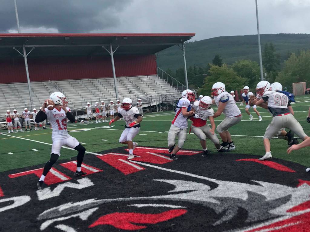 Mount Si Wildcats junior quarterback Clay Millen, left, drops back in the pocket before delivering a pin-point pass during a spring practice session on June 6 at Mount Si High School in Snoqualmie. Shaun Scott/staff photo