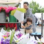 Emi Baba and Aj Baba, 2 of North Bend choose some fresh flowers at the farmers markets opening day.