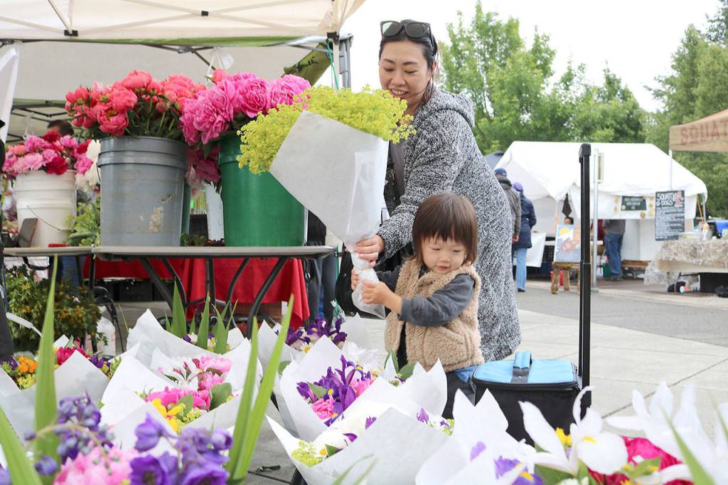 Emi Baba and Aj Baba, 2 of North Bend choose some fresh flowers at the farmers markets opening day.