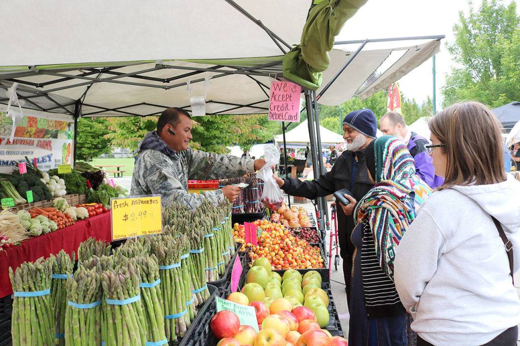 Stephanie Quiroz/staff photos                                Customers buy vegetables at the North Bend Farmers Market opening day on June 6.