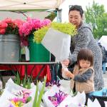 Emi Baba and Aj Baba, 2 of North Bend choose some fresh flowers at the farmers markets opening day.