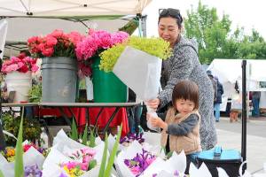 Emi Baba and Aj Baba, 2 of North Bend choose some fresh flowers at the farmers markets opening day.