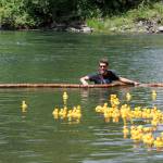 A volunteer holds the net to make sure none of the rubber ducks are lost to the river. Evan Pappas/Staff Photo
