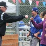 Olivia Corbin crosses home plate and fist bumps an umpire while team Snoqualmie parent Brandon Duffy stands in the background. Andy Nystrom / staff photo