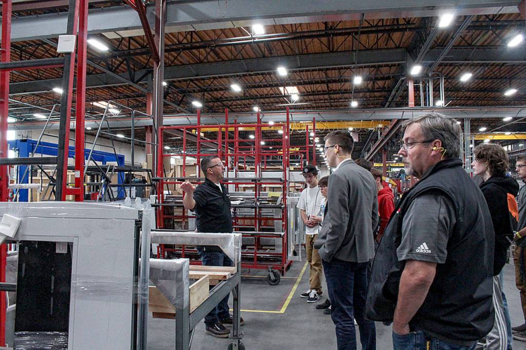 Jayme Smith leads a group of local students through the operations at Allegion (Technical Glass Products) in Snoqualmie during a Manufacturing Day event Oct. 4. Natalie DeFord/Staff photo.
