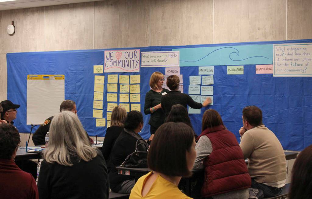 Natalie DeFord/staff photo                                Una McAlinden has a participant place an issue on the board during a town hall meeting discussion about Snoqualmies values and future on Oct. 10 at Mount Si High School.