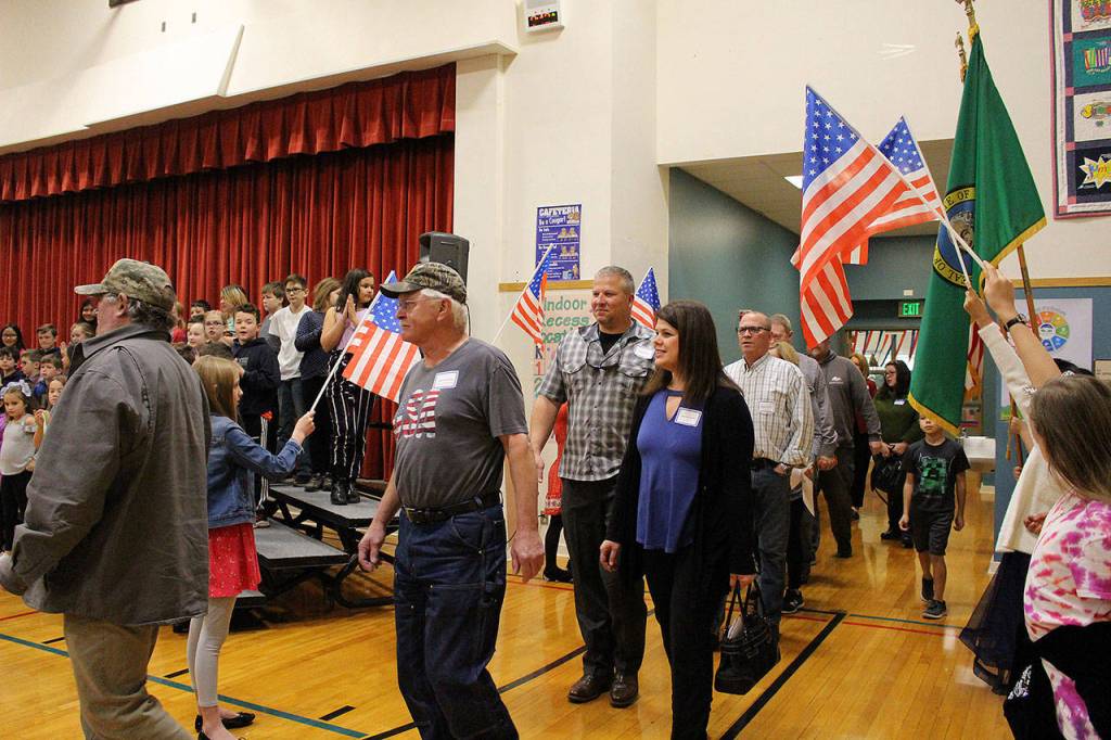 Desi Cuddihys fourth-grade students welcome veterans, including Navy veterans Mark and Angie Kennedy (center) as they enter the Snoqualmie Elementary Veterans Day assembly on Nov. 8. Madison Miller / staff photo