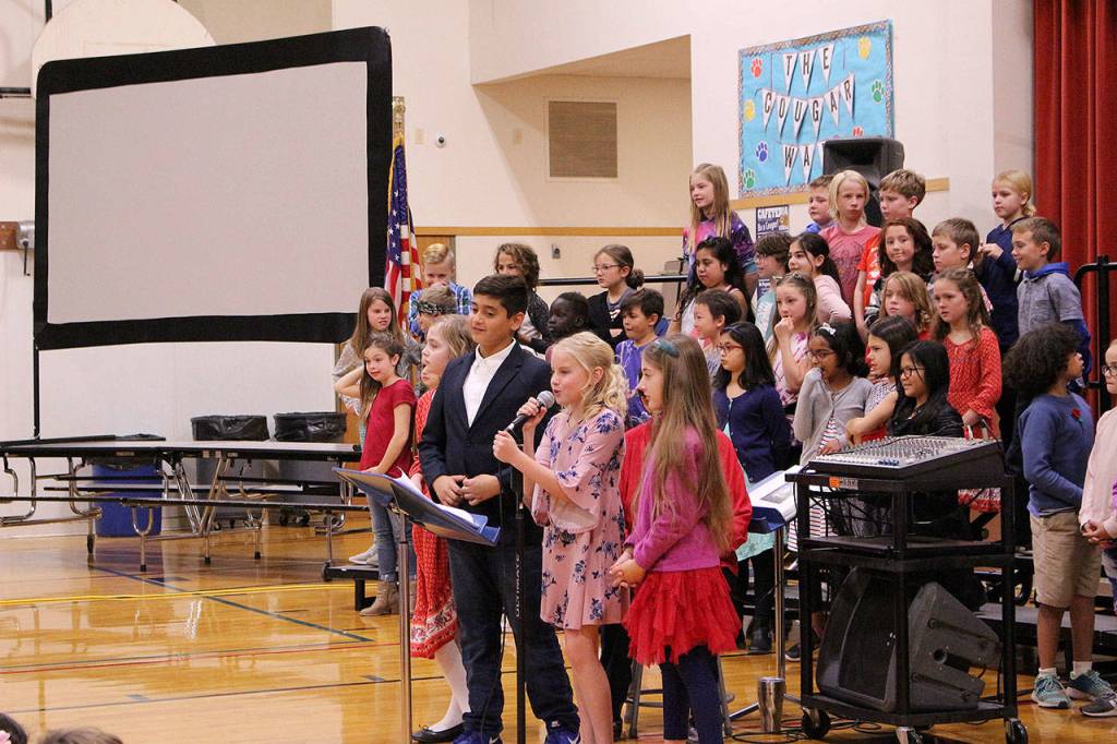 Four of Desi Cuddihys fourth grade class students lead the 11th annual Snoqualmie Elementary Veterans Day assembly on Nov. 8. From left: Emery Giles, Gabriel Natarajan, Rachel Rigby and Annabelle Nieman. Madison Miller / staff photo