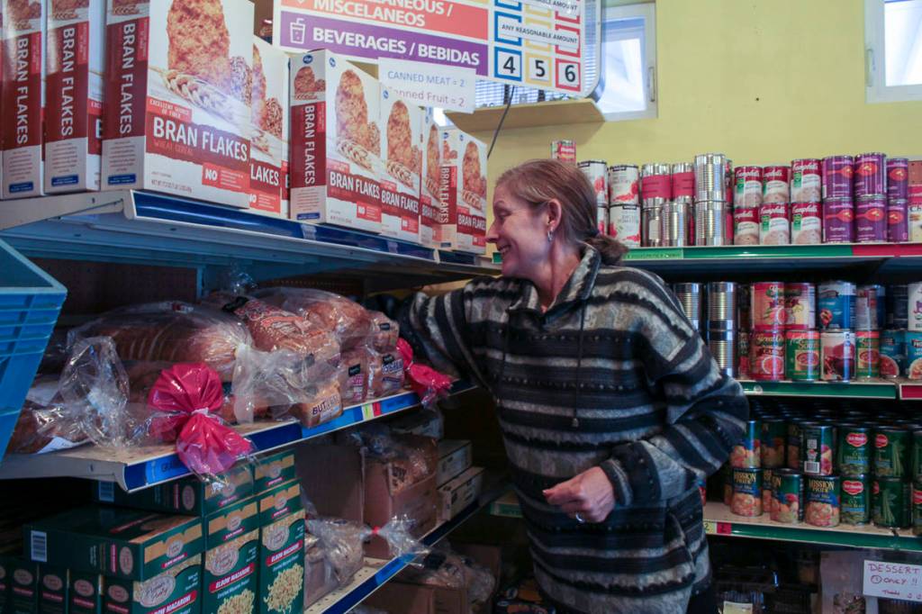 Heather Walsh, Snoqualmie Valley Food Bank operations manager, stocks a bread shelf. Natalie DeFord/staff photo