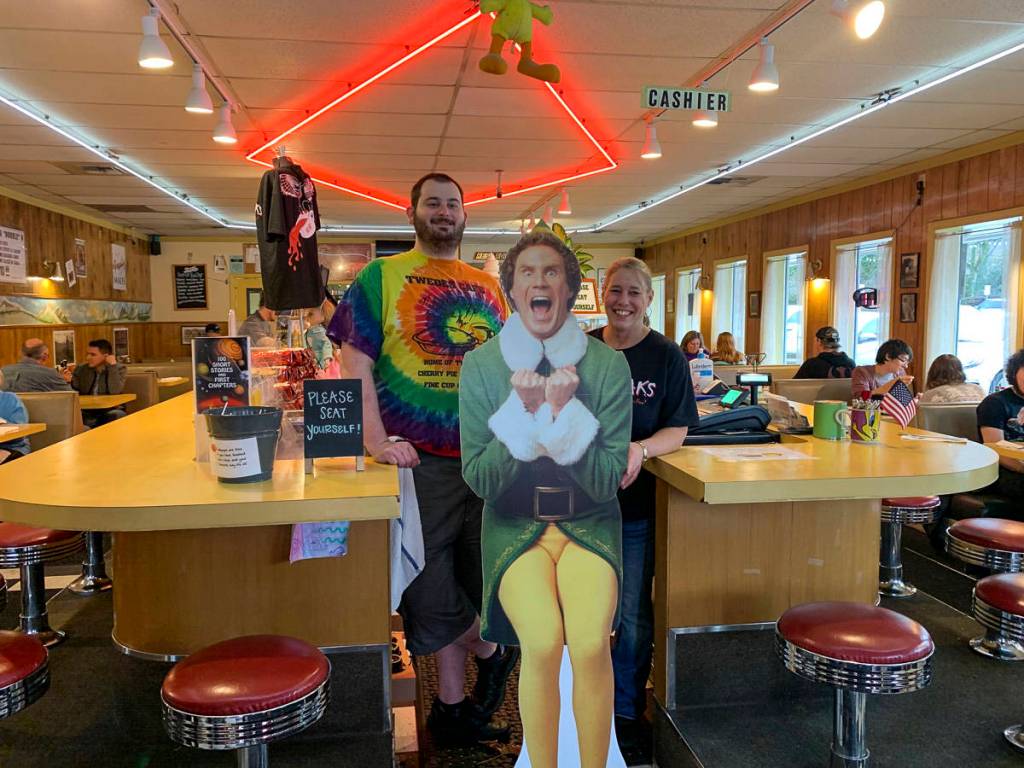 Jacob Pass and Anita Young at Twedes Cafe with Buddy the Elf during a North Bend Downtown Foundation photo campaign promoting downtown businesses. Natalie DeFord/staff photo