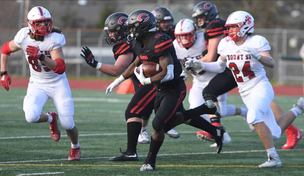 Mount Si defenders Andrew Edson (85) and Caleb Dalgleish chase after Camas running back Jacques Badolato-Birdsell (middle) during a 4A state semifinal on Nov. 30. Photo courtesy of Calder Productions