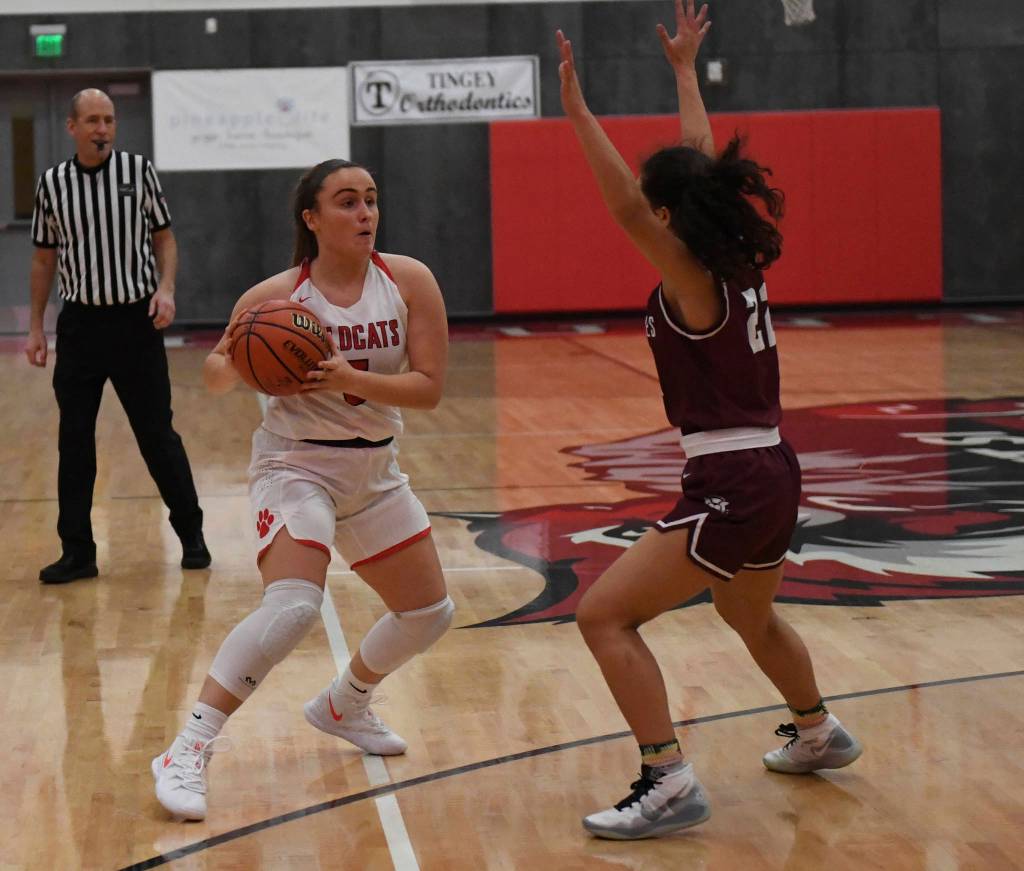 Mount Si senior Izzy Smith (left) looks to make a pass during the Wildcats 56-37 victory over Holy Names on Dec. 4. Photo courtesy of Calder Productions