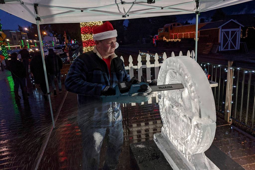 Ice carver Brian Mitchell of Seattle carves a work commemorating the 50th anniversary of the Northwest Railway Museums Santa Train. It took Mitchell about two hours to complete the work, a combination of three separate pieces fuzed together. Corey Morris/staff photo