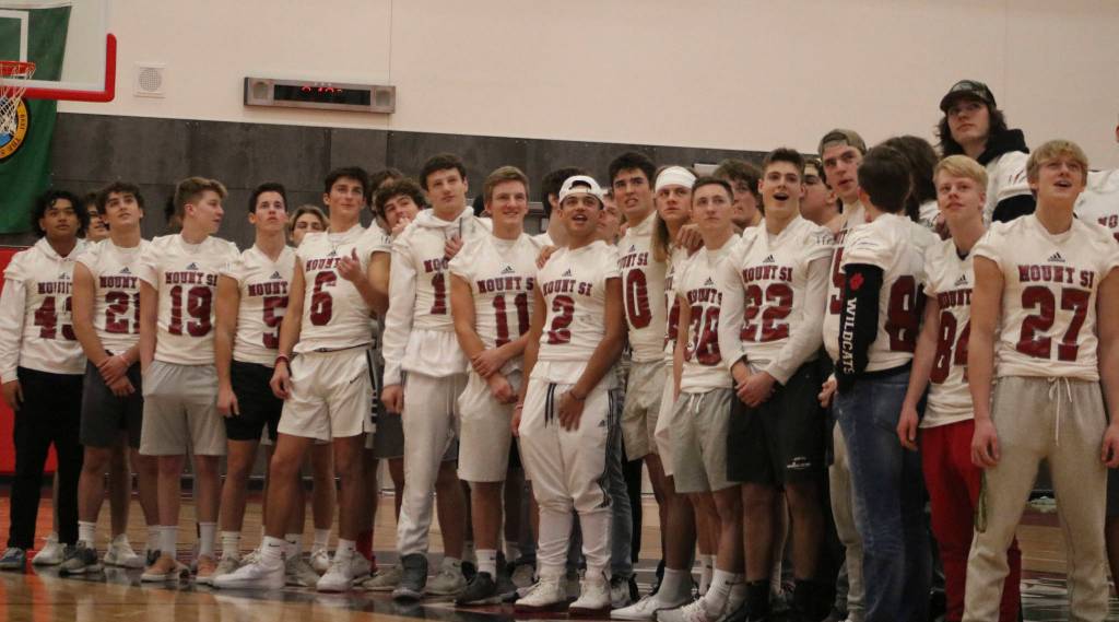 Members of the Mount Si football team watch a highlight montage from their 2019 season during halftime of the boys basketball game on Dec. 14.