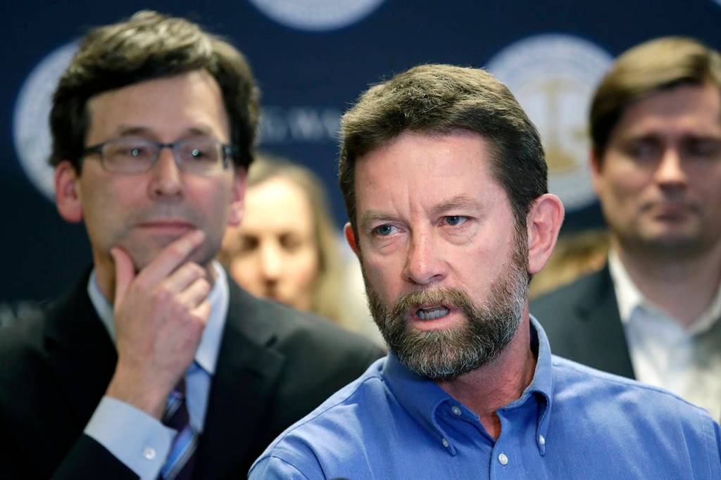 Washington state Attorney General Bob Ferguson (left) looks on as Paul Kramer, the father of a teenage son who survived a mass shooting in Mukilteo, speaks at a news conference announcing legislation to combat mass shootings in the state, Thursday in Seattle. (AP Photo/Elaine Thompson)