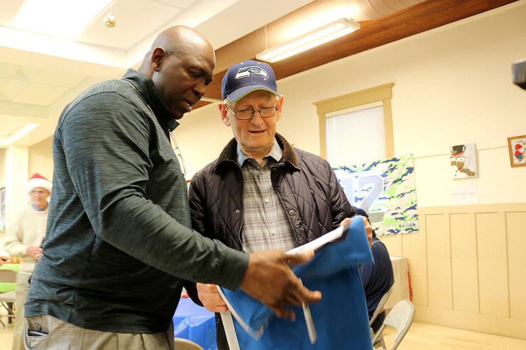 Seahawks legend Alonzo Mitz signs Herb Altmanns 12s flag at Sno-Valley Senior Center on Dec. 13. Stephanie Quiroz/staff photo