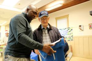 Seahawks legend Alonzo Mitz signs Herb Altmanns 12s flag at Sno-Valley Senior Center on Dec. 13. Stephanie Quiroz/staff photo