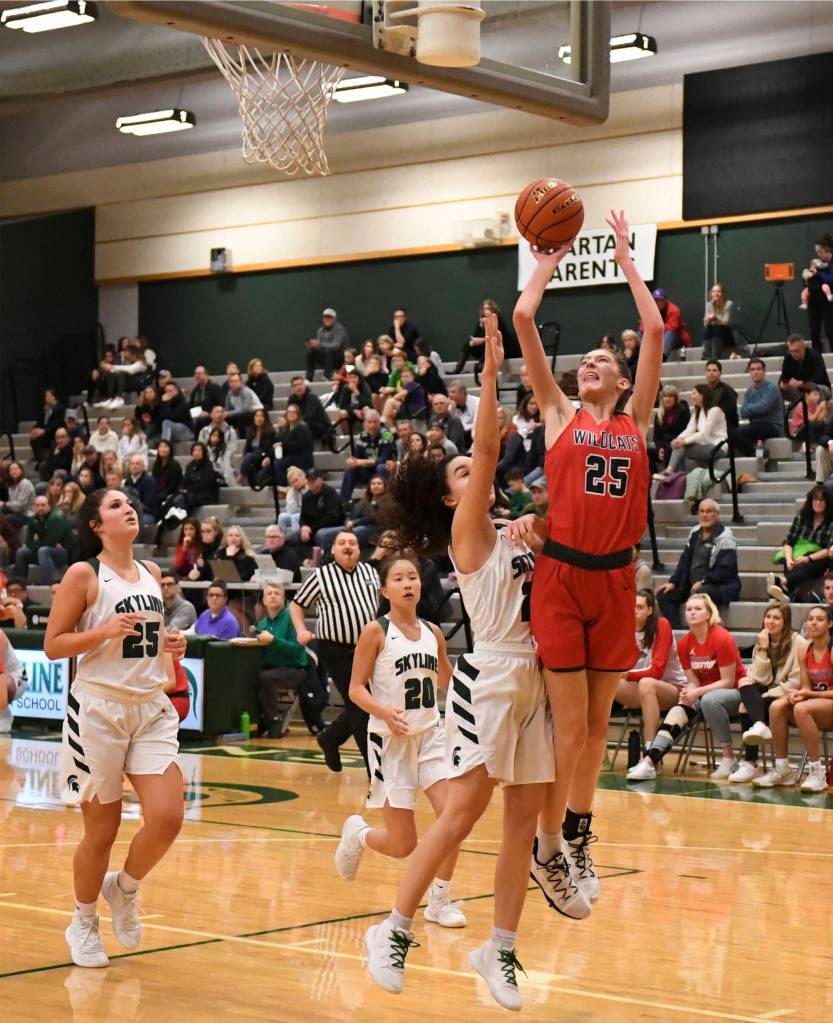 Mount Si sophomore forward Lauren Glazier (right) jumps over a Skyline defender during the Wildcats 41-18 victory over the Spartans on Jan. 3 at Skyline High School. Photo courtesy of Calder Productions