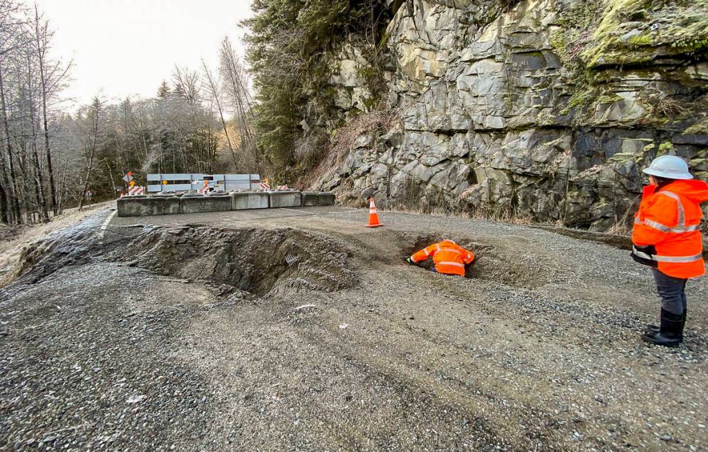 Beyond a clearly marked barricade, King County Road Services workers conduct a brief initial assessment of a landslide that occurred on Dec. 20, severely damaging Middle Fork Road, which will remain closed for an unknown extended period of time. It is extremely dangerous for pedestrians and bike traffic to go around the barricade. Photo courtesy of King County Road Services.