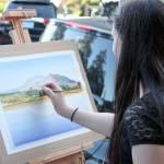 Jacqueline Tribble painting during a previous Finally Friday Art and Wine Walk event. Courtesy photo