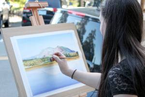 Jacqueline Tribble painting during a previous Finally Friday Art and Wine Walk event. Courtesy photo