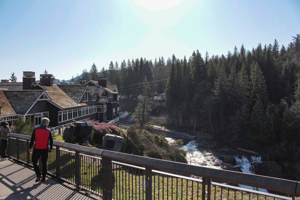 Natalie DeFord/Staff photo. Passersby enjoy a sunny days view of Snoqualmie Falls and the Salish Lodge Spa.