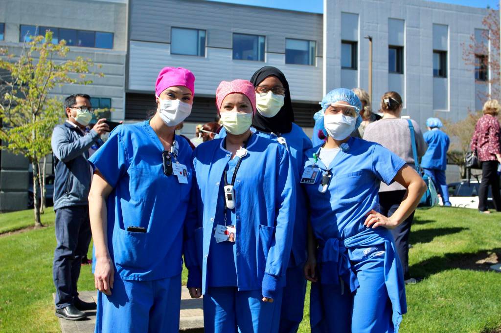 St. Francis Hospital employees pose for a photo, before laughing about smiling behind their masks. Olivia Sullivan/staff photo