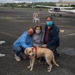 Niaya with her new family meet for the first time at Renton Municipal Airport. The labrador-beagle mix travelled thousands of miles to meet her new family in the midst of the coronavirus pandemic. Photo by Andre Osorio/For the Renton Reporter