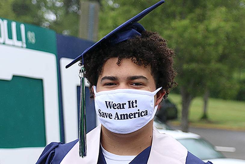 In this file photo, Tayshon Cottrell dons his graduation cap and gown, along with a face mask reading: Wear it! Save America at Todd Beamer High Schools virtual graduation walk recording on May 20, 2020, in Federal Way. Olivia Sullivan/Sound Publishing