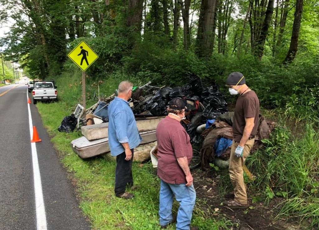 Friends of the Trail crew members scope out a pile of trash before cleaning it. Contributed by Wade Holden