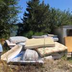 A man looks over a pile of mattresses which will be cleaned up and hauled away by Friends of the Trail. 	Contributed by Wade Holden