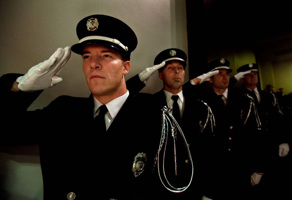 Everett firefighters salute at a Gary Parks memorial ceremony at Everett Community College in 2012. (Michael OLeary / Herald file)