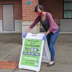 A library staffer setting up a Curbside to Go sign. Photo courtesy KCLS
