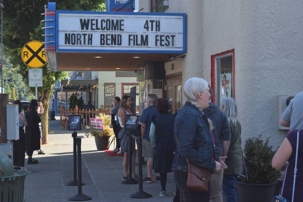 Residents wait outside the North Bend Theater on the opening night of North Bend Film Fest on Thursday, July 15. Photo by Conor Wilson/Valley Record