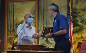 Snoqualmie Mayor Matt Larson presents SnoValley Chamber president, Earl Bell, with a community service award from the city Aug. 9. Photo by Conor Wilson/Valley Record