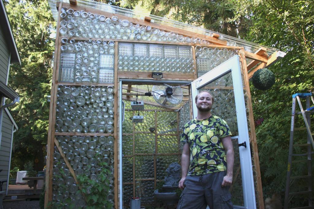 Axton Burton stands proudly in front of the greenhouse he made in his parents yard in Duvall, Wash. (photo by Cameron Sheppard)