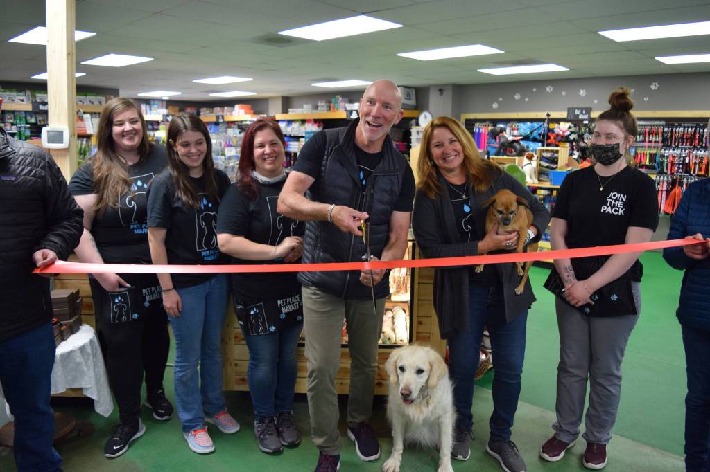 Owners Chris and Amy Hawkins (center) celebrate the 15 year anniversary and grand re-opening of Pet Place Market in North Bend on April 20, alongside staff and their dogs: Nala (l) and Jazzy. Photo Conor Wilson/Valley Record.