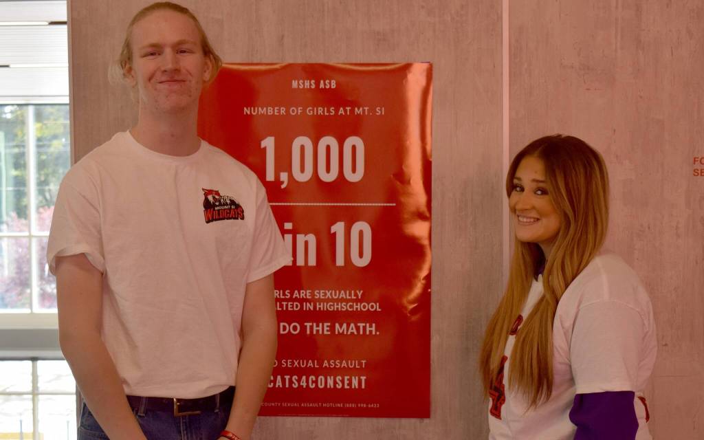 Mount Si High School students Garner Brown (right) and Marisol May-Gutierrez stand in front of a poster for Cats4Consent, a sexual assault awareness campaign they organized. Photo by Conor Wilson/Valley Record