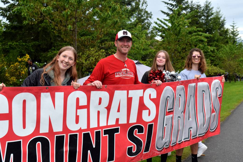 Valley residents hold up a sign during the Mount Si High School Senior Car Parade on June 4. Photo by Conor Wilson/ Valley Record
