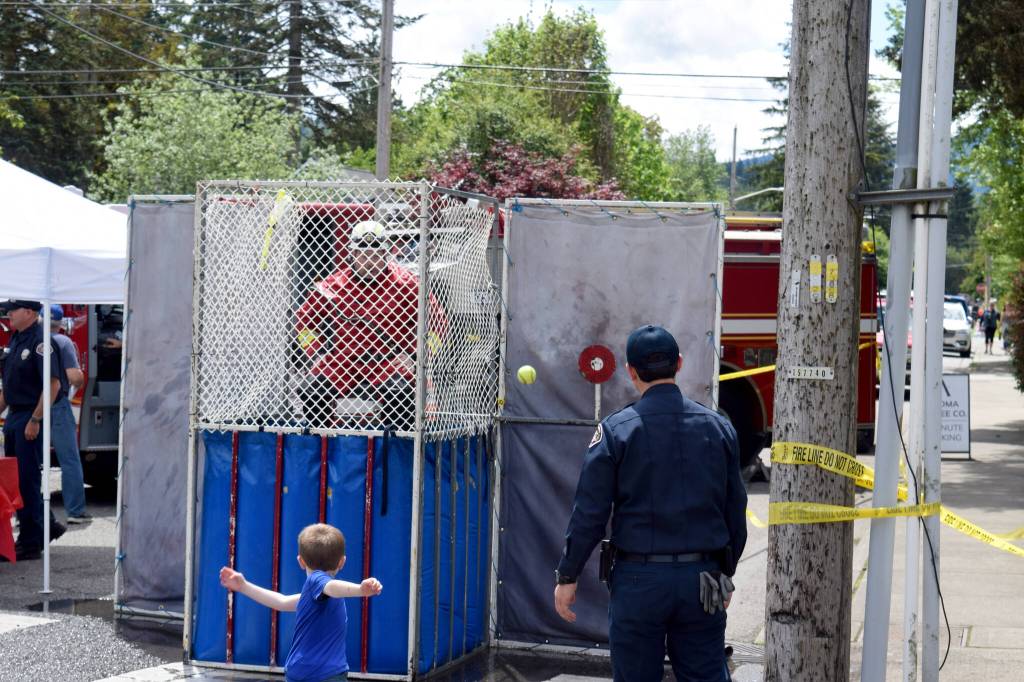 A boy throws a ball at the dunk tank.