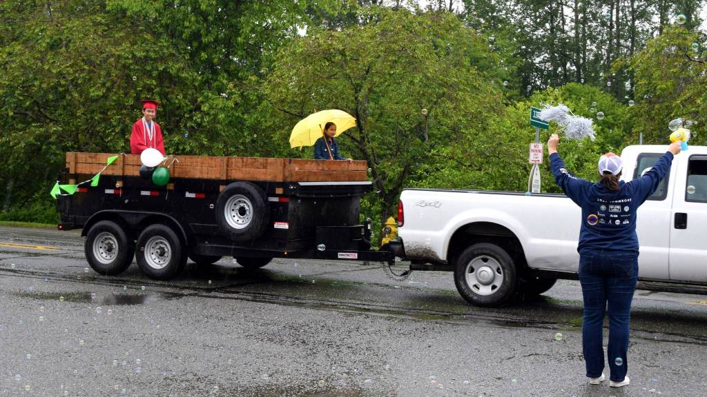 A high school graduate is driven by during the Fall City Graduation Parade. Photo Conor Wilson/Valley Record.
