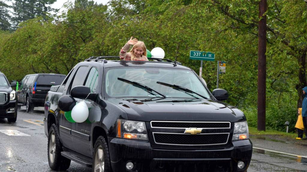 A girl waves to the crowd during the Fall City Graduate Parade June 17. Photo Conor Wilson/Valley Record.